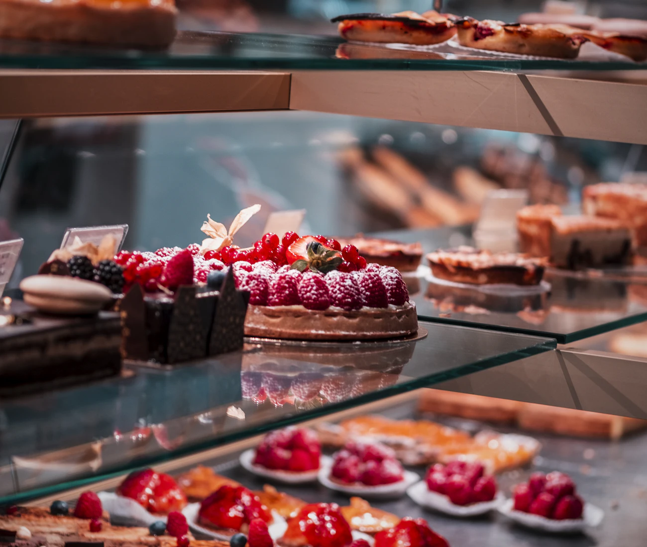 Fruit tarts and chocolate cakes in a display case