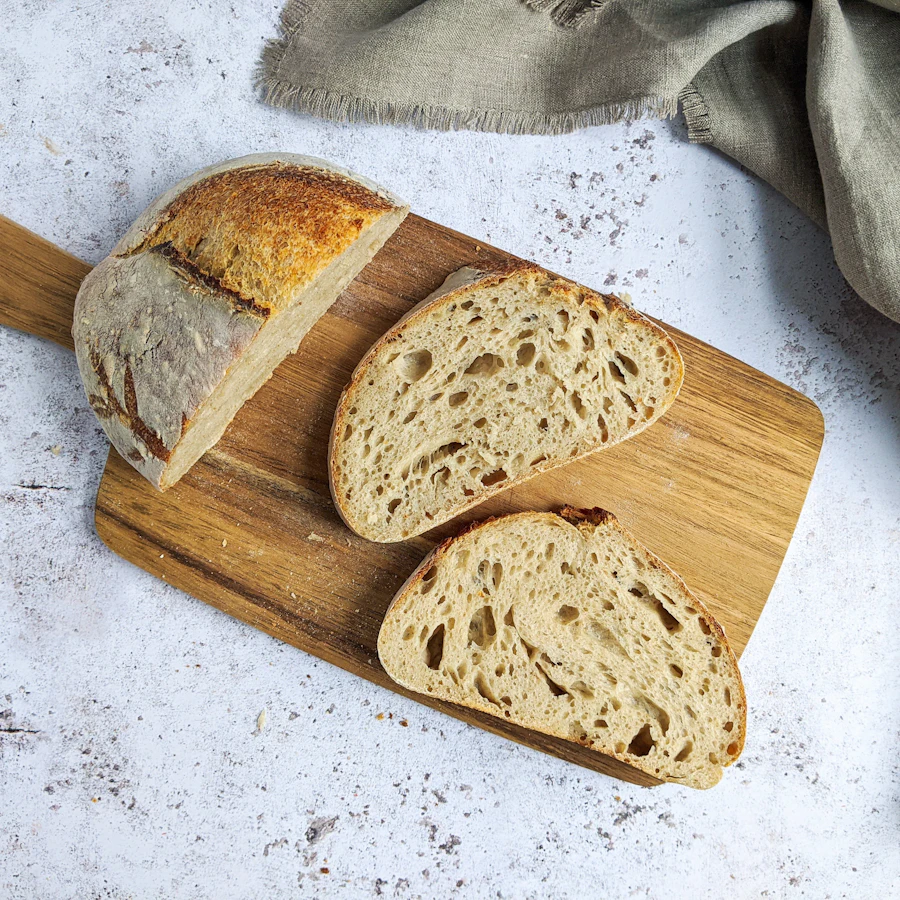 A loaf of sourdough, sliced on a board